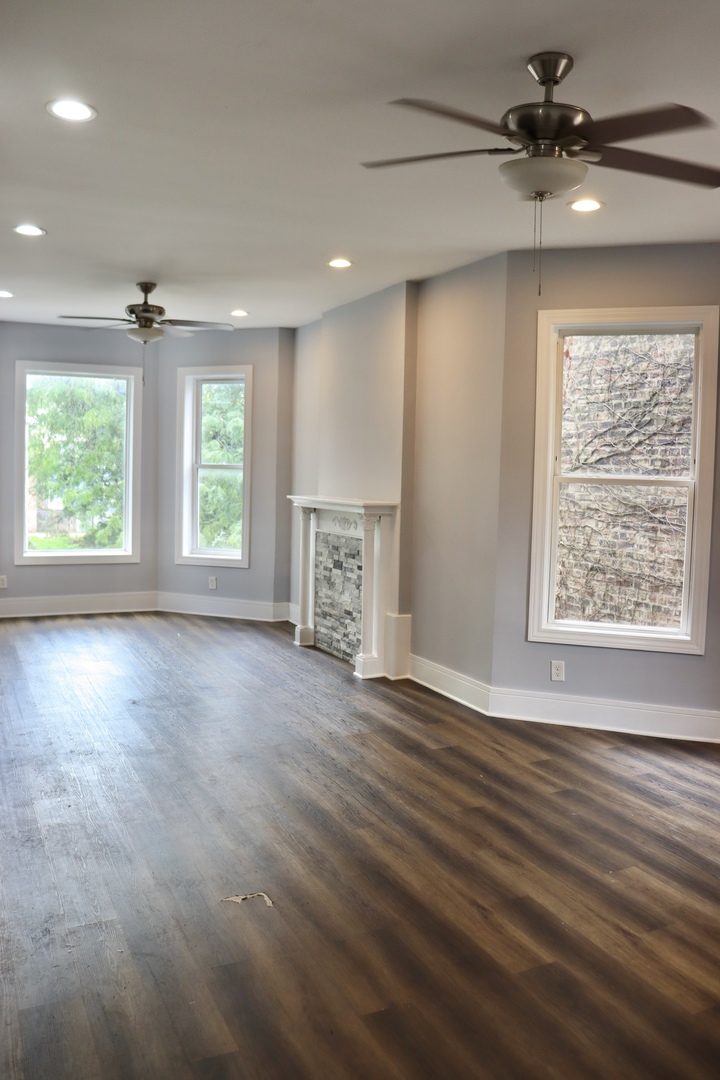5718 South Sangamon Street, Unit 2 Chicago, IL 60621 - Photo 6 of 35 an empty room with wooden floor chandelier fan and windows