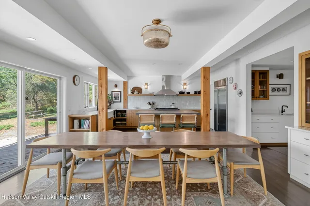 a dining table with chairs and kitchen view
