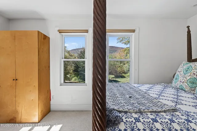 a bedroom with a bed couch and windows