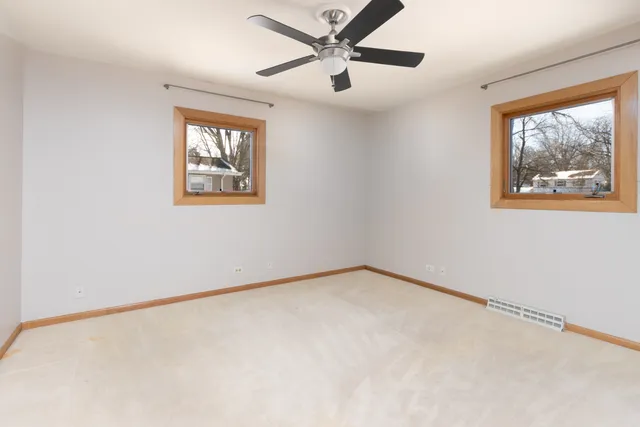 an empty room with a window and a ceiling fan