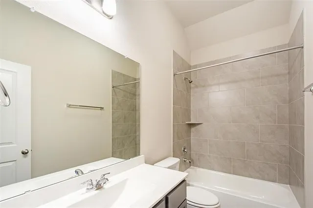 a bathroom with a bathtub shower sink vanity and toilet