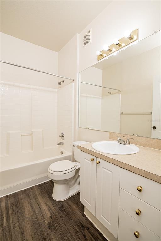 3391 South Kirkman Road, Unit 1216 Orlando, FL 32811 - Photo 18 of 33 a bathroom with a granite countertop sink a toilet a mirror and shower