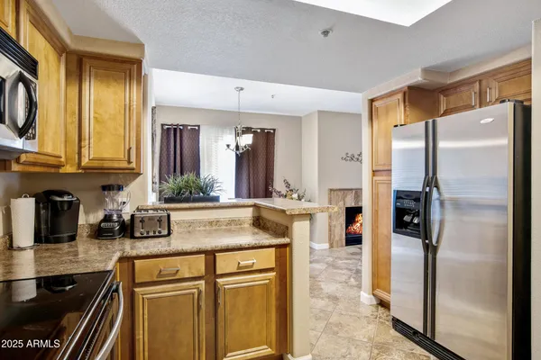 a kitchen with stainless steel appliances granite countertop a refrigerator and a sink