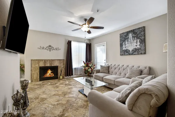 a living room with furniture a fireplace and a flat screen tv