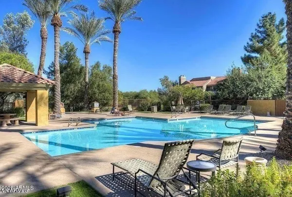 a view of a swimming pool with lounge chairs in patio