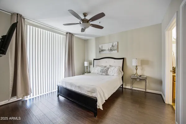 a bedroom with a bed and a ceiling fan