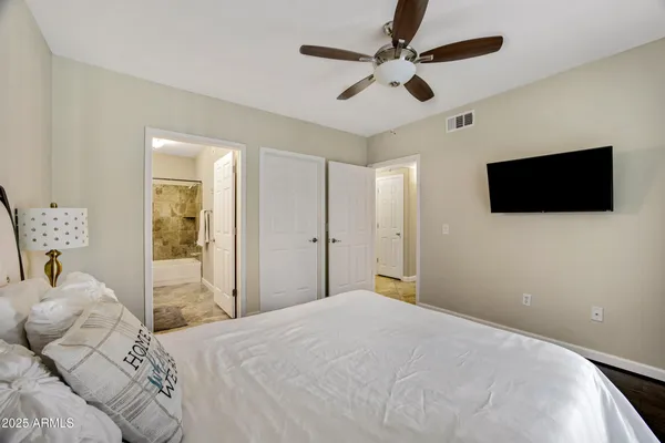 a bedroom with a bed window and a flat screen tv