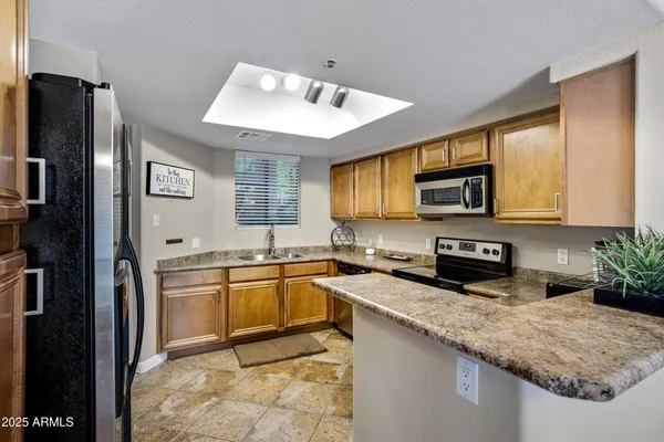 a kitchen with stainless steel appliances granite countertop a refrigerator stove microwave and sink