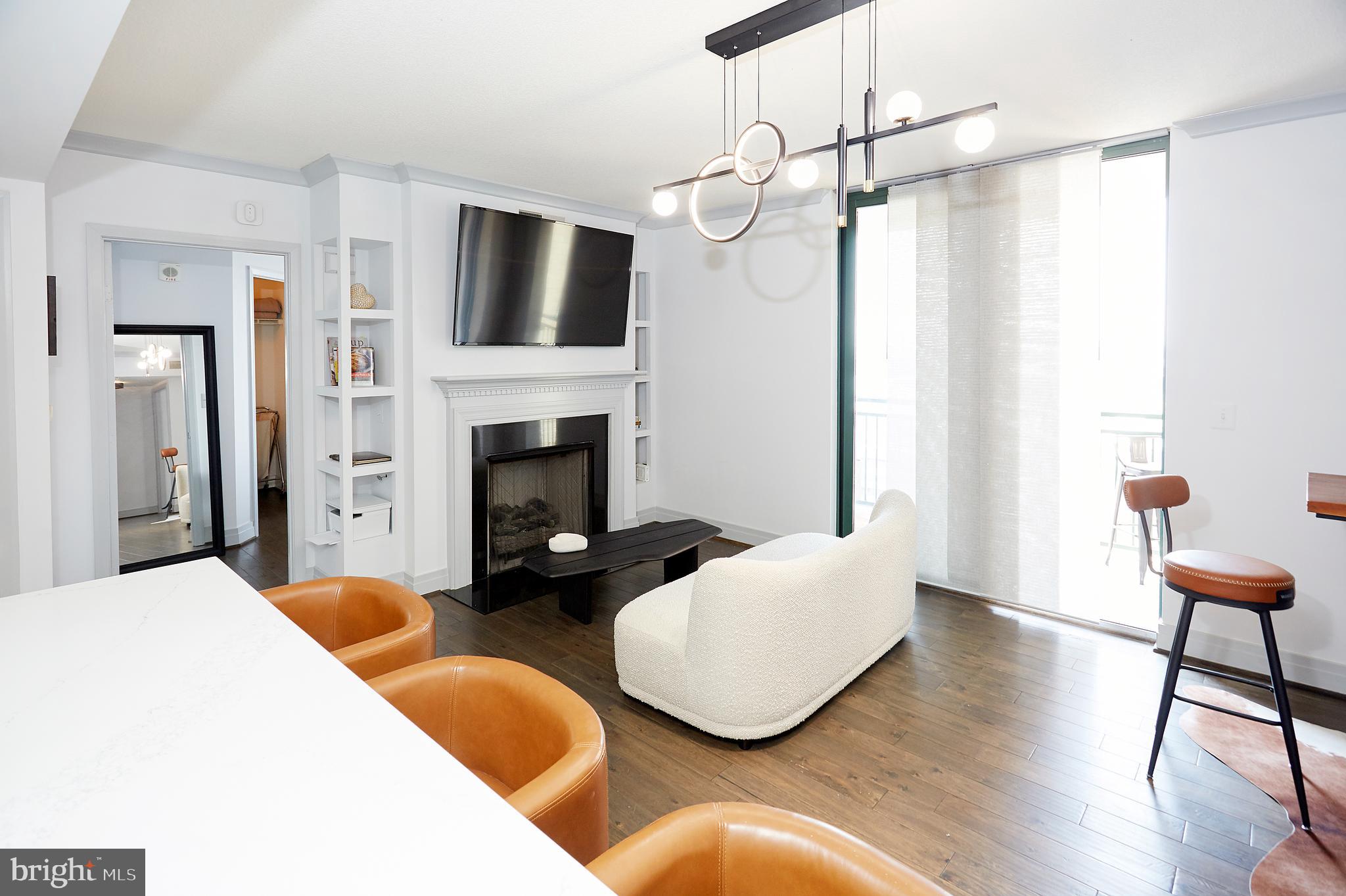 414 Water Street, Unit 2601 Baltimore, MD 21202 - Photo 13 of 51 a living room with furniture a fireplace and a flat screen tv