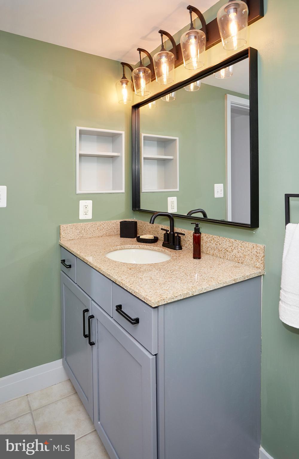 414 Water Street, Unit 2601 Baltimore, MD 21202 - Photo 26 of 51 a bathroom with a granite countertop sink and a mirror