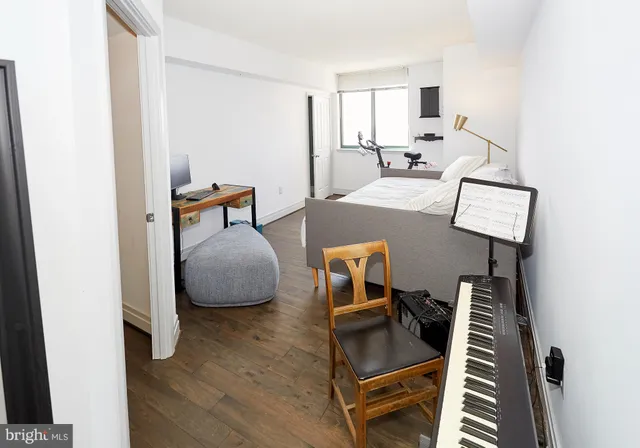 a bedroom with a bed and wooden floor