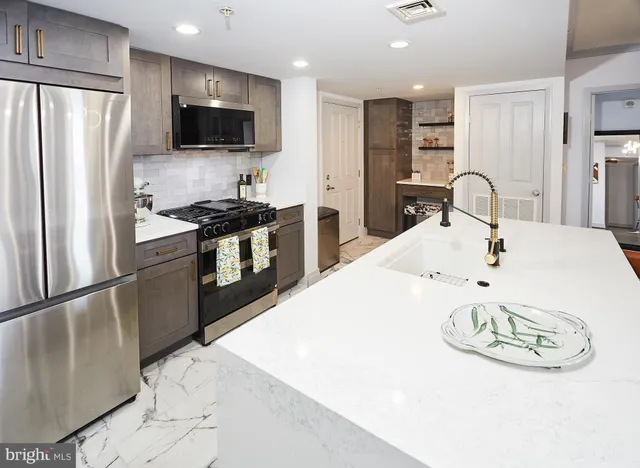 a kitchen with stainless steel appliances a stove a refrigerator and a refrigerator