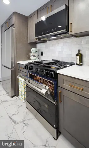 a kitchen with stainless steel appliances granite countertop a stove and a microwave