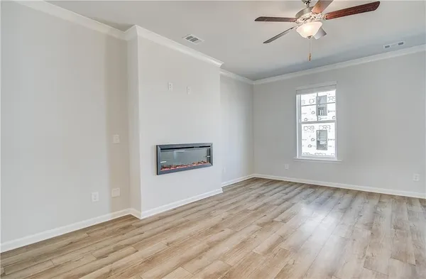 a view of an empty room with a window and a ceiling fan