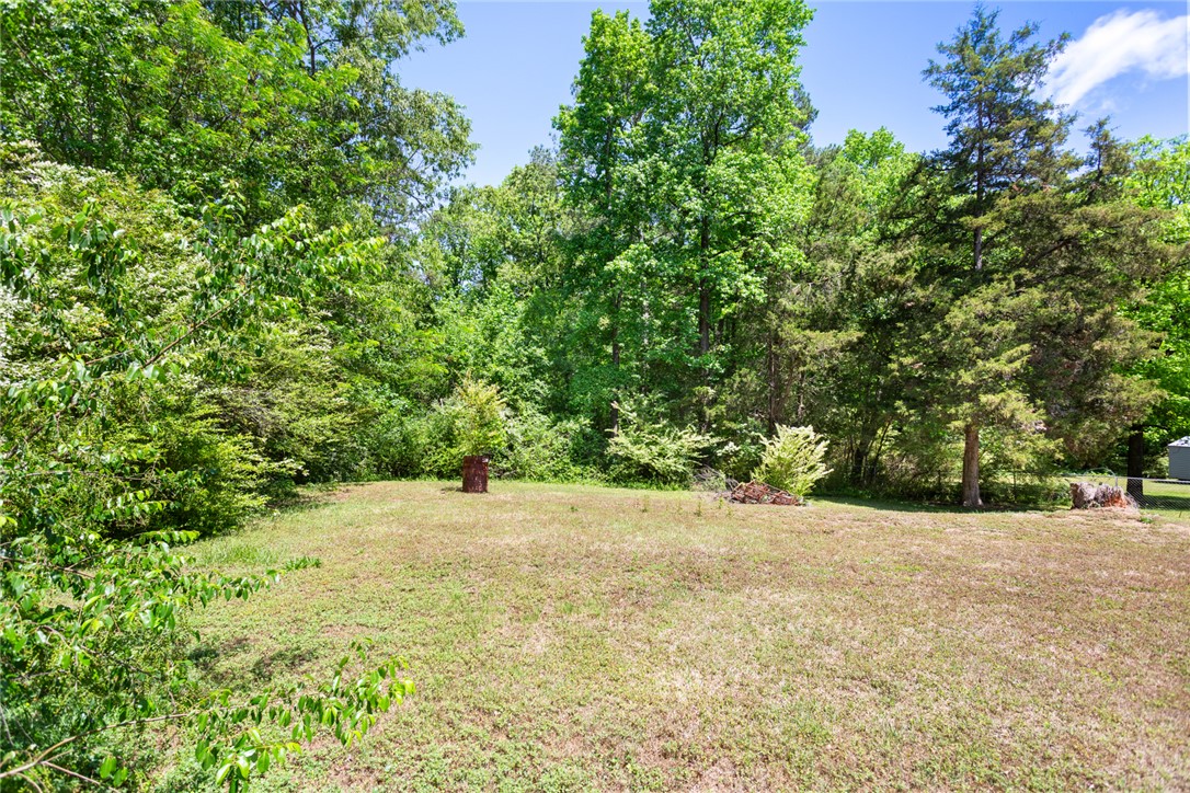 209 Short Cut Road Westminster, SC 29693 - Photo 3 of 27 A spacious yard bordered by lush trees offers a serene natural setting.