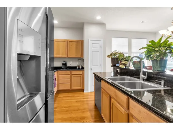 a kitchen with kitchen island granite countertop a sink stainless steel appliances and cabinets