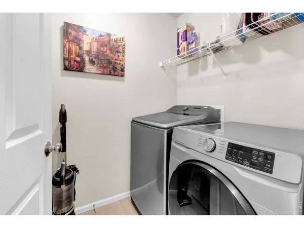 a utility room with dryer washer and a view of living room
