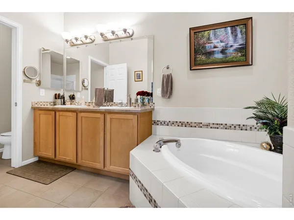 a bathroom with a tub a sink and mirror
