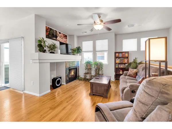 a living room with furniture fireplace and a large window