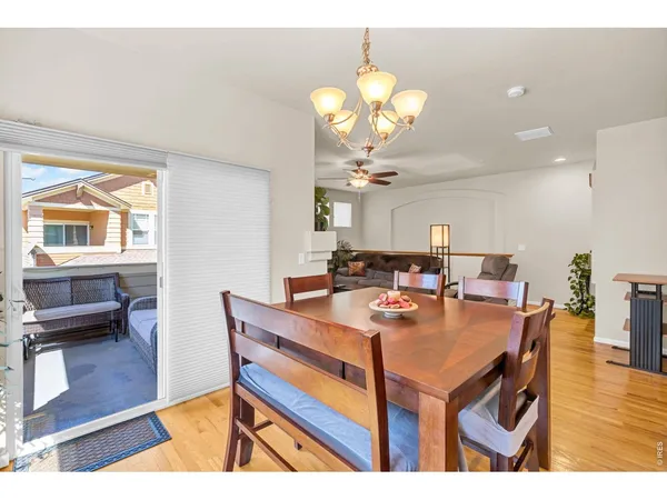 a view of a dining room with furniture a chandelier and wooden floor