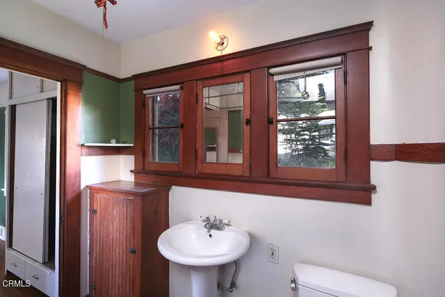 a bathroom with a toilet a sink and mirror