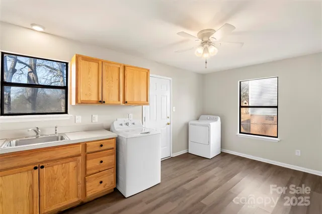 a room with a double vanity sink and mirror with wooden floor