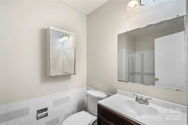 a bathroom with a granite countertop sink a toilet and a mirror