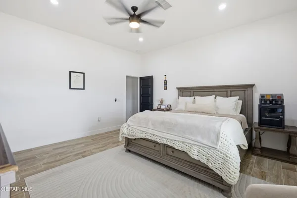 a spacious bedroom with a bed and a chandelier