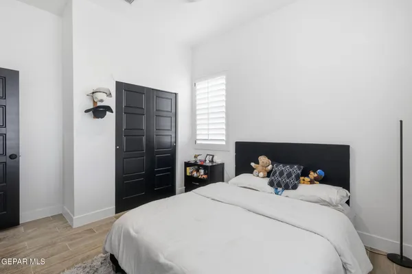a bedroom with a bed and wooden floor