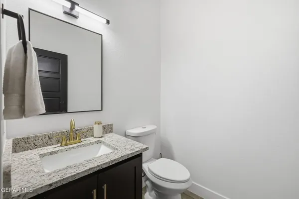 a bathroom with a granite countertop sink and a mirror