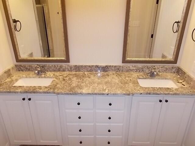 2002 102nd Street, Unit B Lubbock, TX 79423 - Photo 14 of 17 a bathroom with a granite countertop sink and a mirror