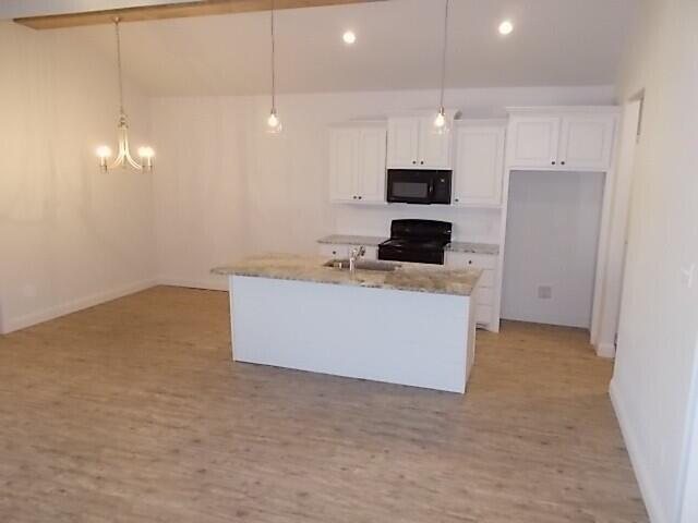 2002 102nd Street, Unit B Lubbock, TX 79423 - Photo 7 of 17 a kitchen with a stove a refrigerator and a microwave
