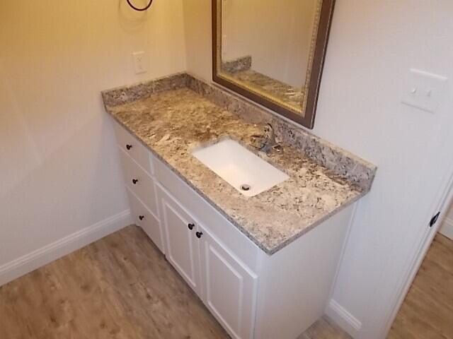2002 102nd Street, Unit B Lubbock, TX 79423 - Photo 9 of 17 a bathroom with a granite countertop sink and a mirror