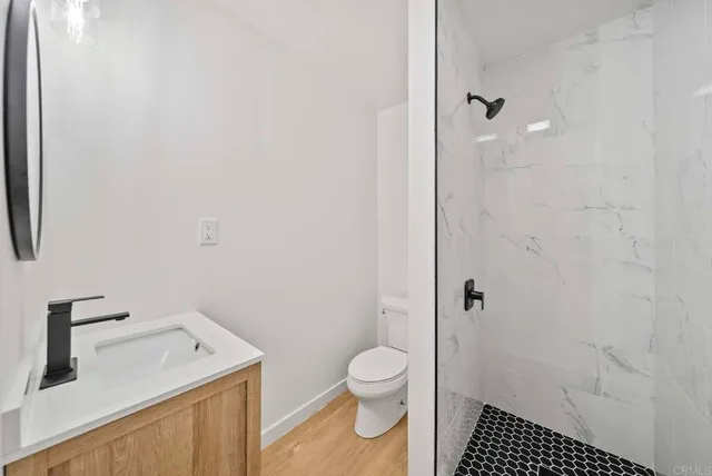a bathroom with a granite countertop toilet a sink and a shower