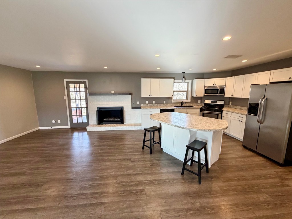 9712 Springdale Road Austin, TX 78754 - Photo 14 of 40 a living room with stainless steel appliances furniture a fireplace a flat screen tv and view kitchen
