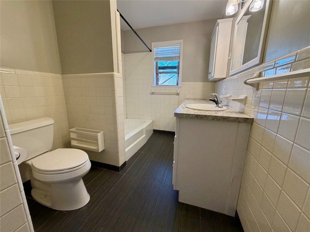9712 Springdale Road Austin, TX 78754 - Photo 22 of 40 a bathroom with a granite countertop toilet sink and mirror