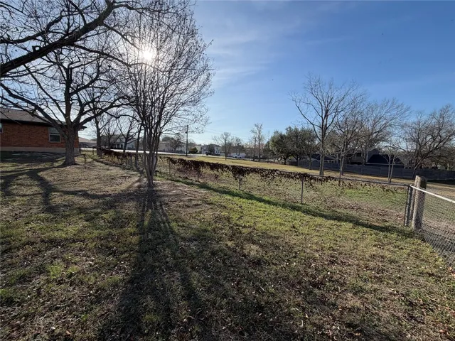 a view of a yard with wooden fence