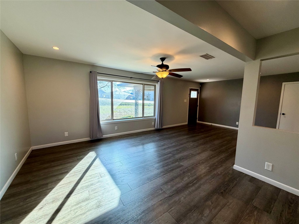 9712 Springdale Road Austin, TX 78754 - Photo 9 of 40 an empty room with wooden floor and windows