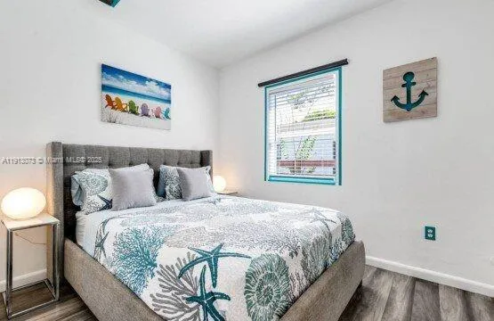 a bedroom with a bed and painting on the wall