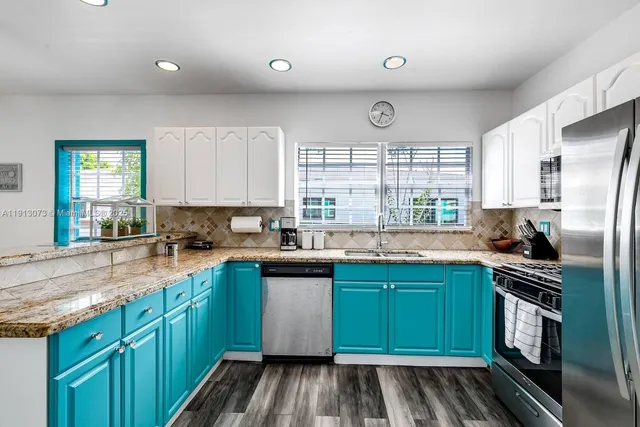 a kitchen with a sink a stove cabinets and a refrigerator