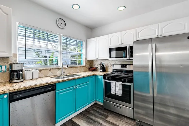 a kitchen with stainless steel appliances granite countertop a stove a sink and a microwave