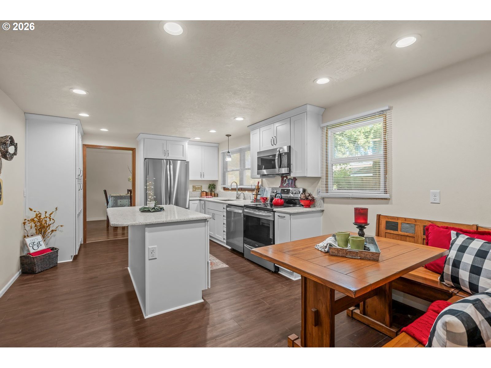 5356 Verda Lane Northeast Keizer, OR 97303 - Photo 14 of 41 a open kitchen with stainless steel appliances kitchen island granite countertop a dining table chairs sink and white cabinets