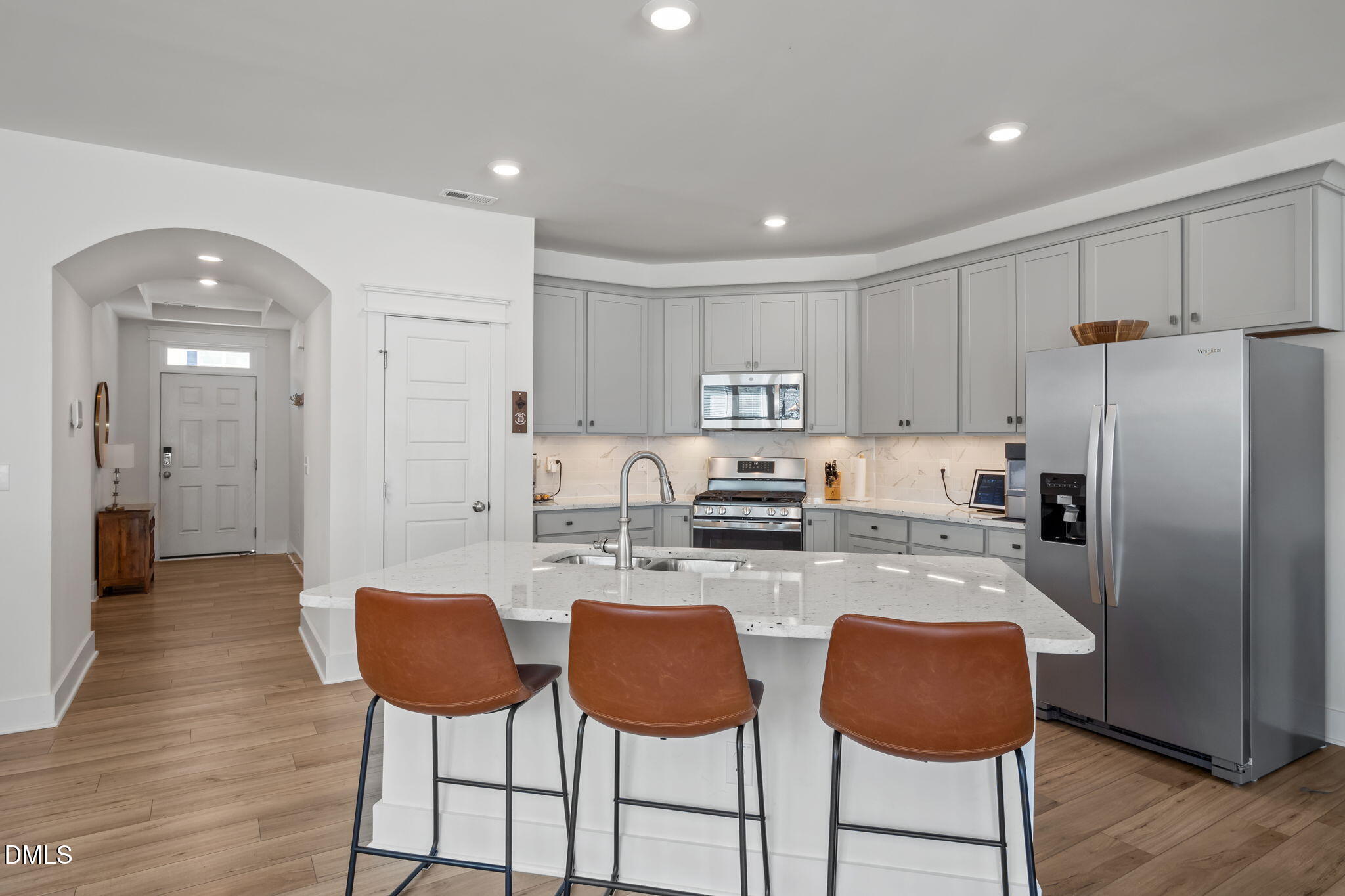 1000 Heartstone Way Durham, NC 27713 - Photo 3 of 43 a kitchen with stainless steel appliances granite countertop a stove a refrigerator a kitchen island with chairs white cabinets and wooden floor