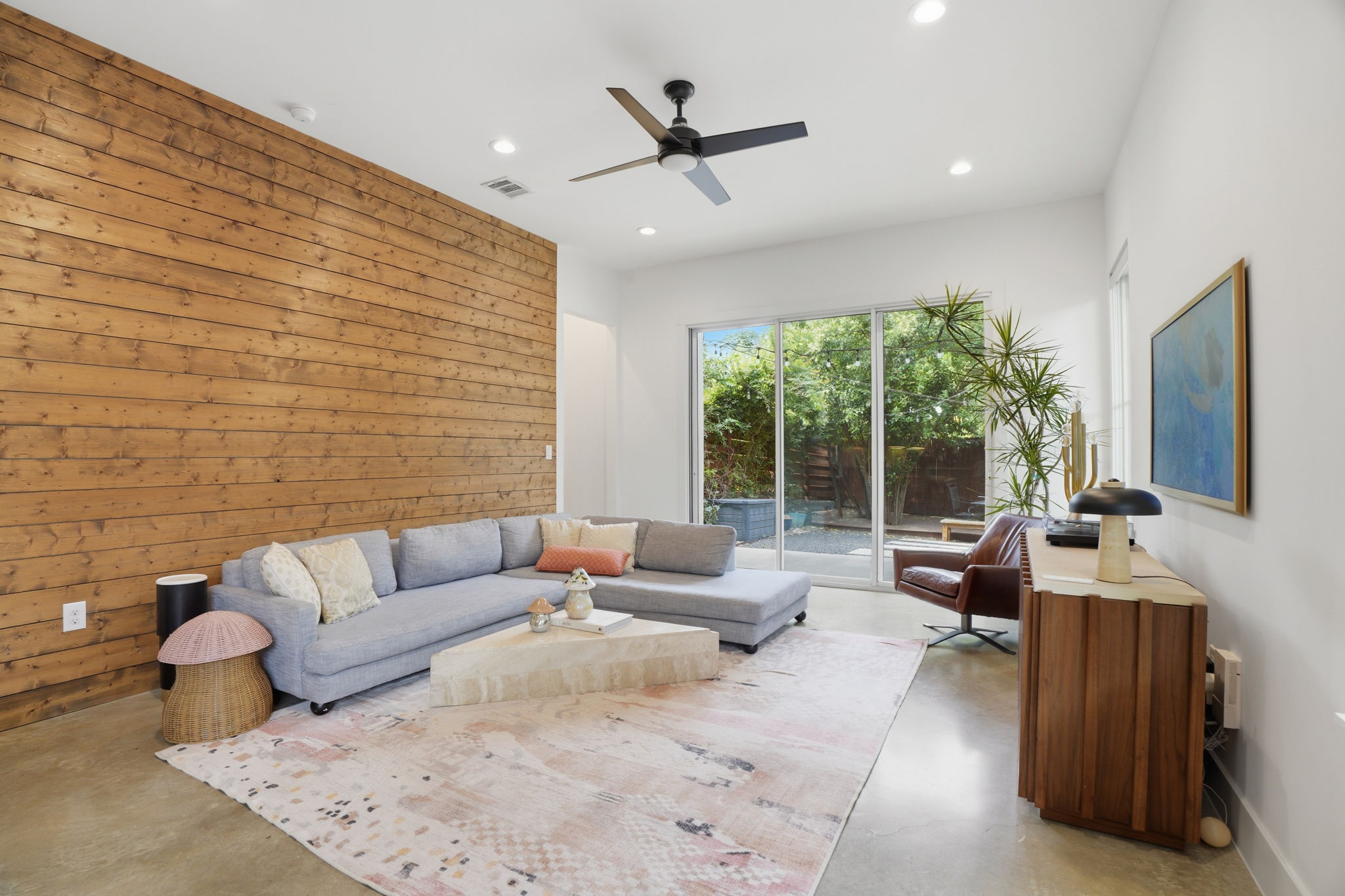 4609 Sara Drive, Unit B Austin, TX 78721 - Photo 16 of 39 A striking wood-paneled accent wall elevates this open living area with direct access to an outdoor retreat.