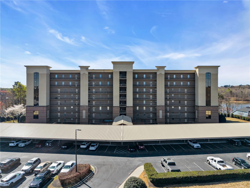 This residential building features multiple balconies and a covered parking area for convenience.