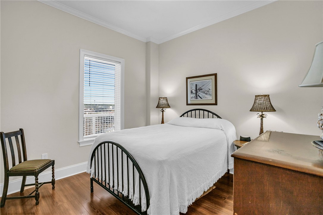 703 Watermarke Lane Anderson, SC 29625 - Photo 5 of 49 This cozy bedroom features hardwood floors and elegant crown molding, creating a serene personal retreat.