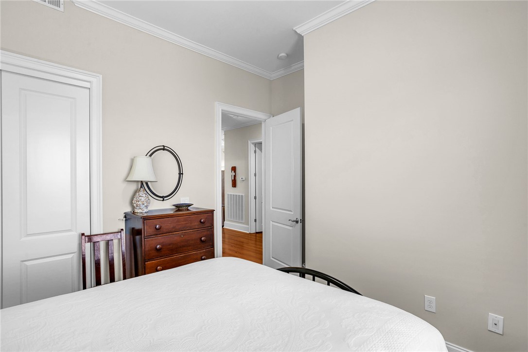 703 Watermarke Lane Anderson, SC 29625 - Photo 7 of 49 This cozy bedroom features elegant crown molding, a built-in closet, and rich hardwood flooring, offering comfort.