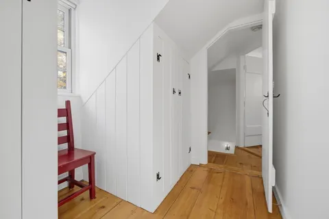 a view of a hallway with wooden floor and staircase