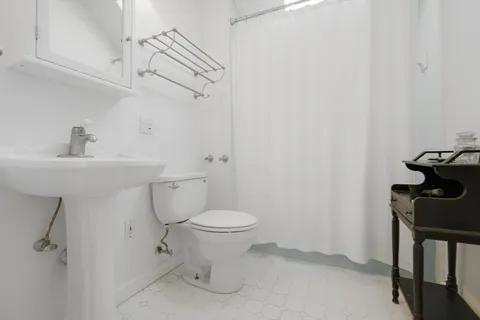 a bathroom with a sink toilet and a mirror