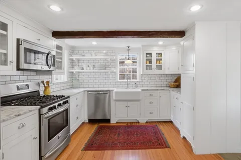a kitchen with granite countertop a stove sink and cabinets